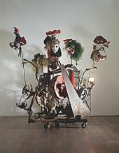 Jean Tinguely, L'Avant-Garde, 1988 Metall, Fasnachtslarven aus Papiermaché, Keilriemen, Holzräder, Elektromotoren, 255 x 205 x 2